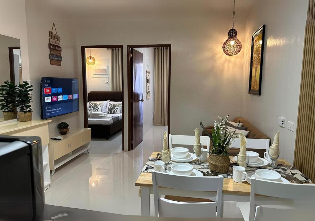 uma sala de jantar e sala de estar com mesa e cadeiras em Affordable Summer Homes with FREE Pool, Gym and Parking near Puerto Princesa Palawan Airport -T21Kunzite em Puerto Princesa