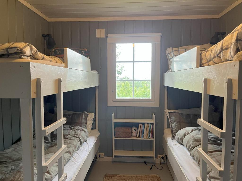 two bunk beds in a room with a window at Cozy family friendly cabin at beautiful location! in Geilo