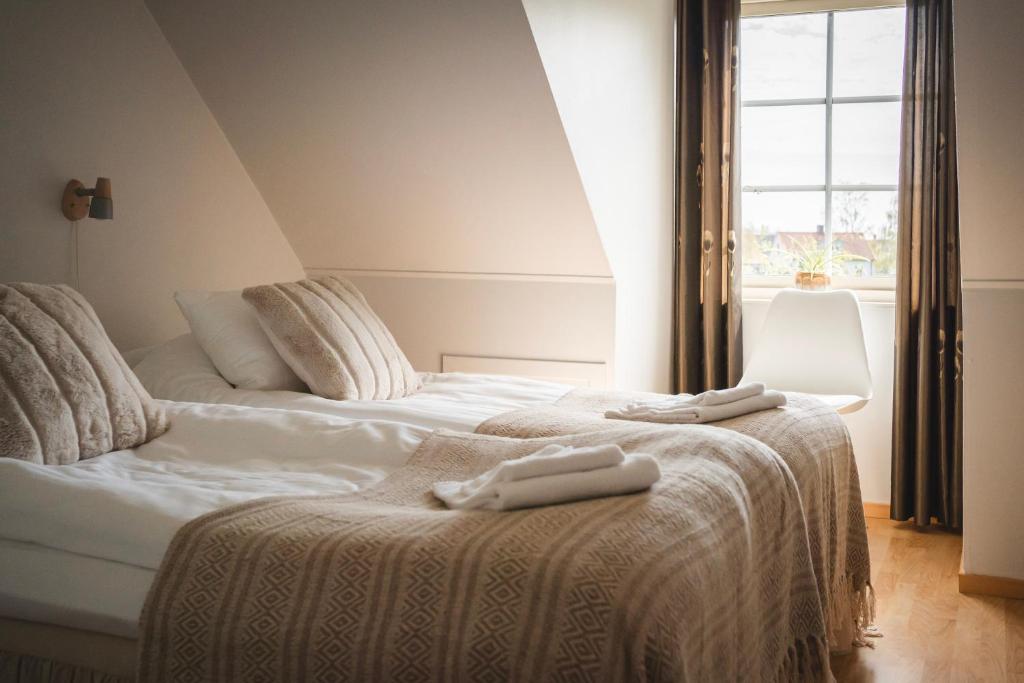 2 camas con toallas en una habitación en Rymligt radhus med trädgård & parkering, en Skurup