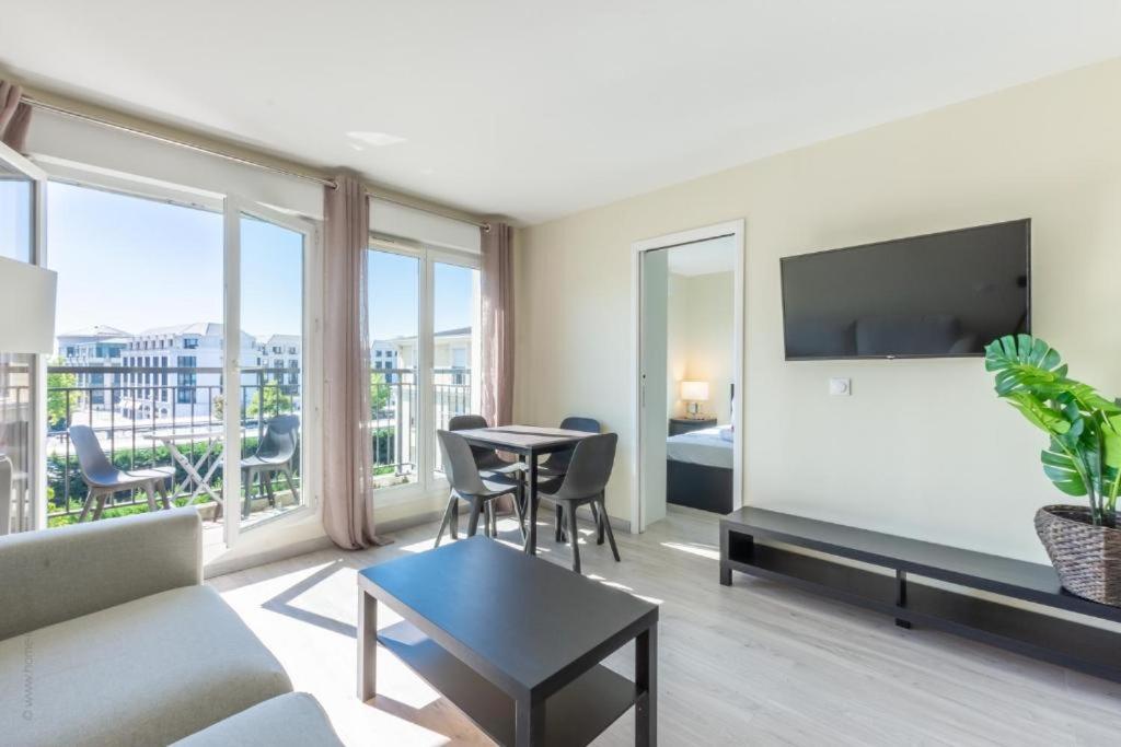 un salon avec un canapé et une table dans l'établissement Appartement moderne pour 6, avec parking et WIFI - Fairytale Factory, à Chessy