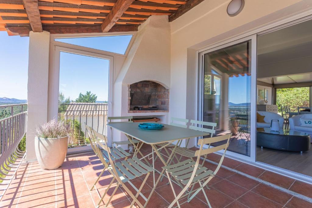 une salle à manger avec une table et des chaises sur un patio dans l'établissement Villa Agachelo avec piscine, à Fréjus