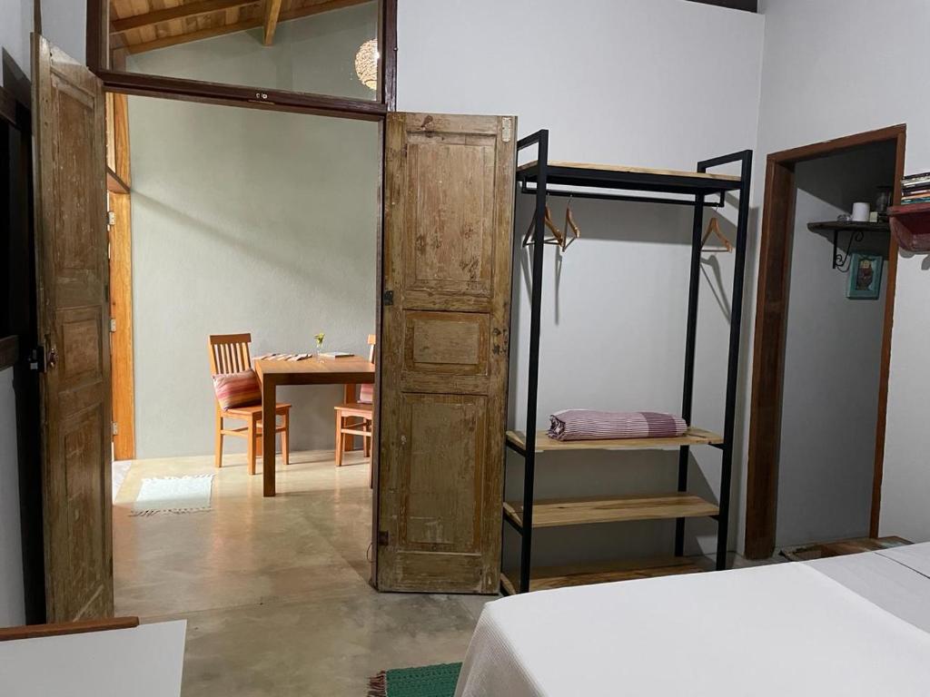 1 dormitorio con 1 cama y 1 mesa y 1 habitación con puerta en Casa no Sul de Ilhabela en Ilhabela