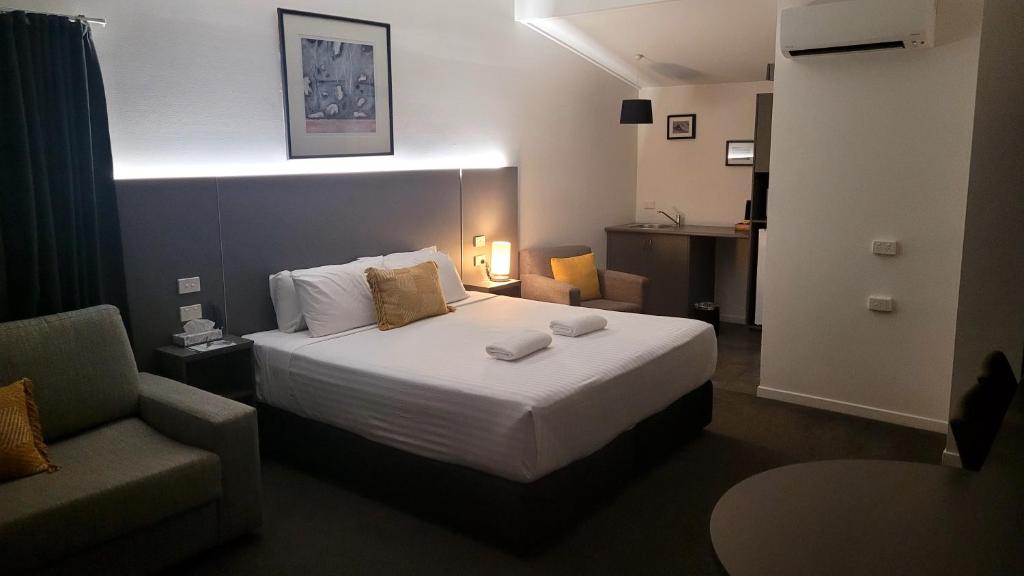 Pokój hotelowy z łóżkiem i krzesłem w obiekcie Fern Bay Motel w mieście Newcastle