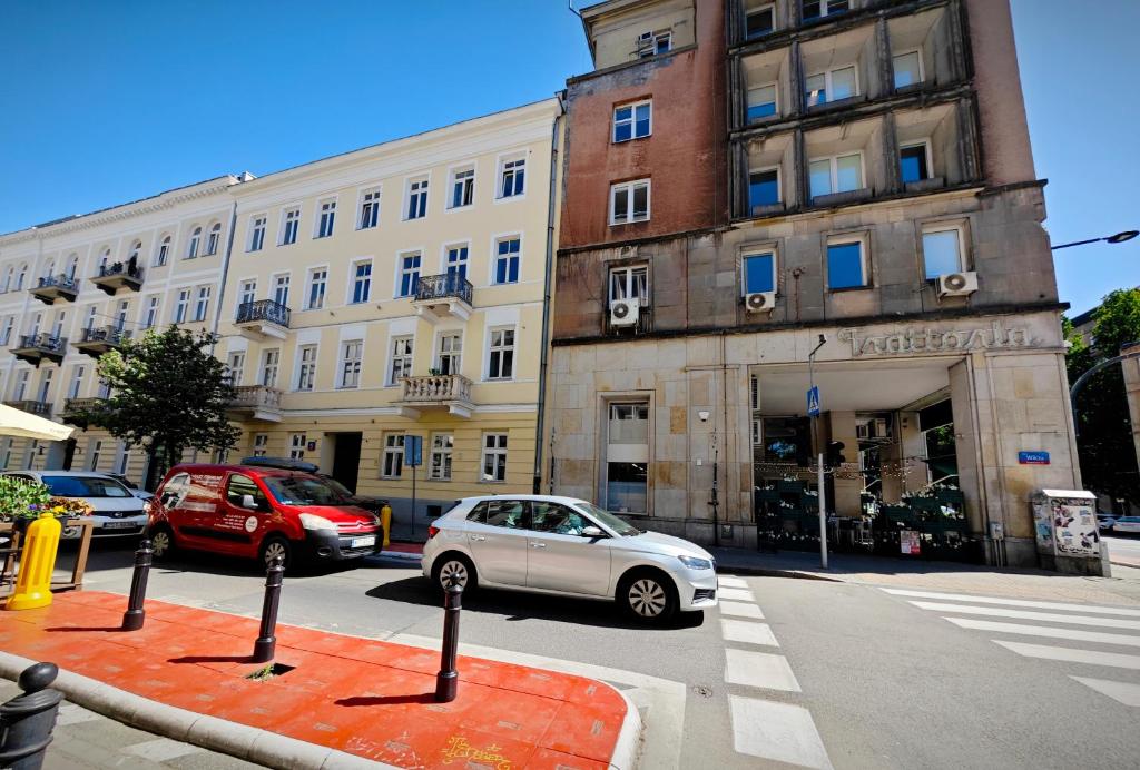 ワルシャワにあるApartamenty Wilcza - City Centerの建物前に駐車した白車