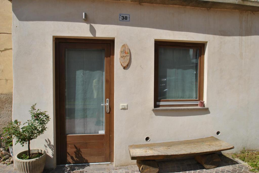 a building with a wooden door and a bench at B&B alla Pieve in Calceranica al Lago