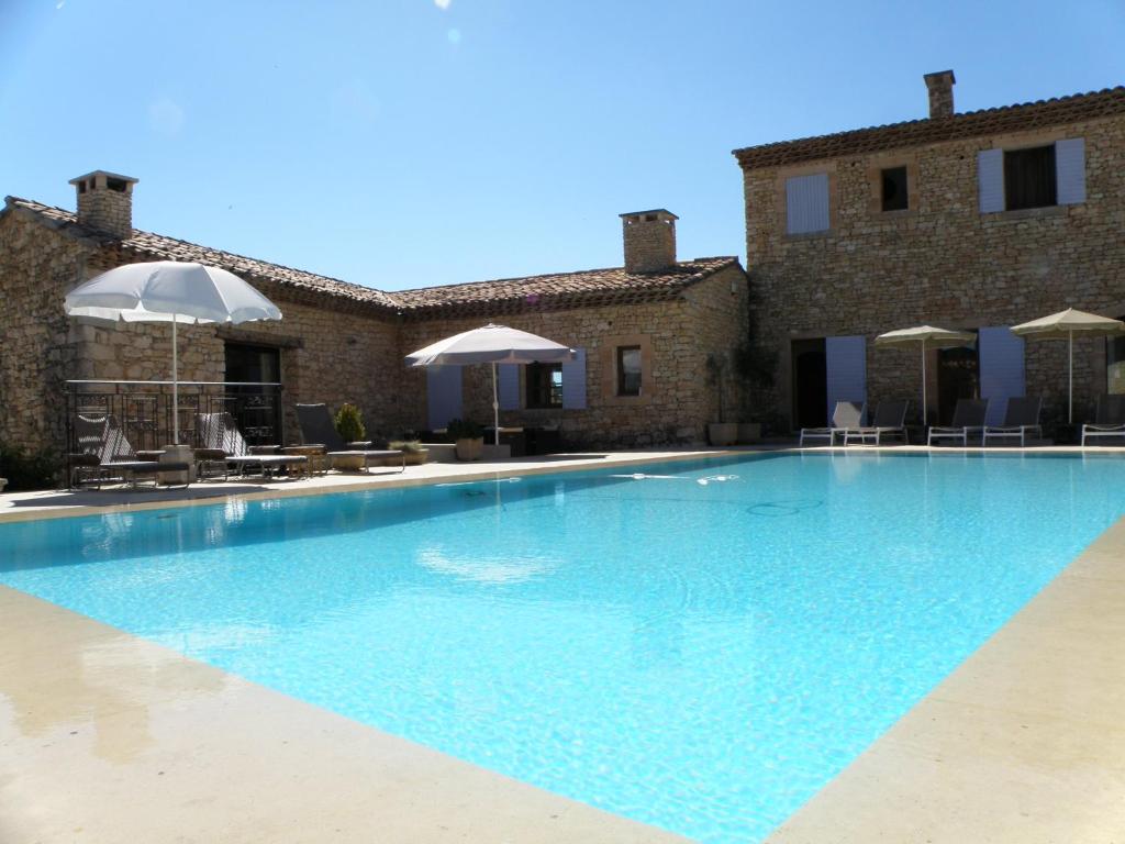 une grande piscine devant un immeuble dans l'établissement Villa Helios, à Rustrel