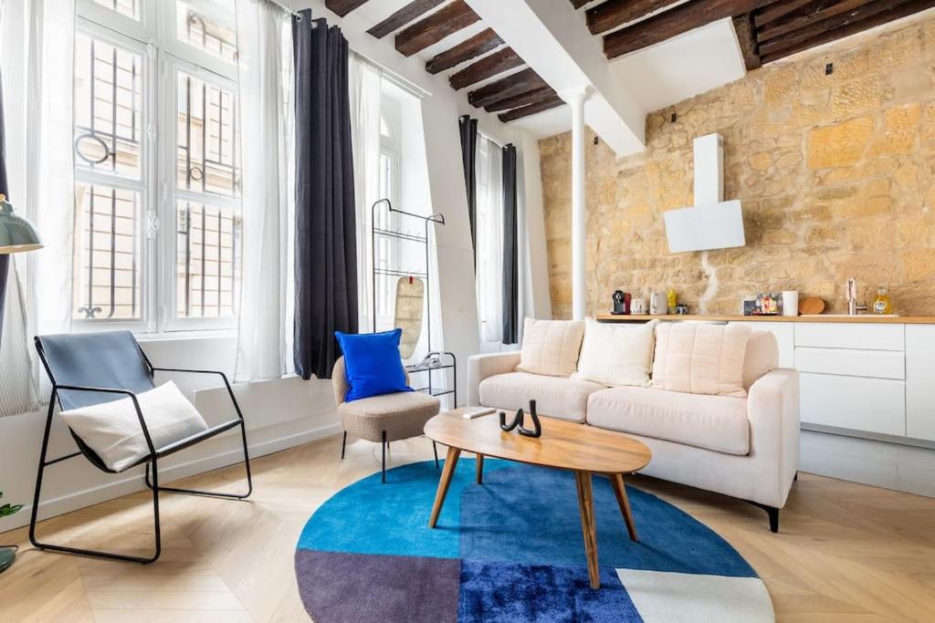 - un salon avec un canapé blanc et un tapis bleu dans l'établissement Typical Parisian Apart#Quatier Latin#Notre Dame#, à Paris