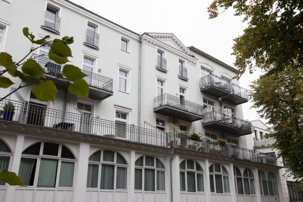 um grande edifício branco com janelas e varandas em H&P Residenz am Kurpark Warnemünde em Warnemünde