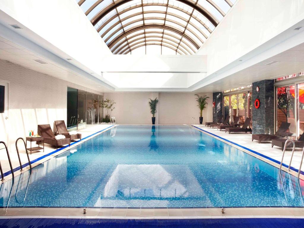 a large swimming pool in a building with a ceiling at Novotel Ambassador Seoul Gangnam in Seoul