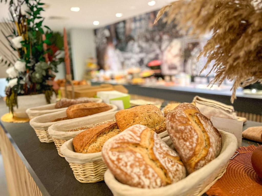 a bunch of breads in baskets on a table at ibis Styles Nimes Gare Centre in Nîmes