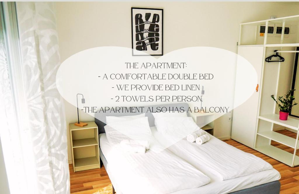 a bedroom with a bed with a quote on the wall at Mátyás Corner Apartments Green Square Studio Apartment II in Budapest