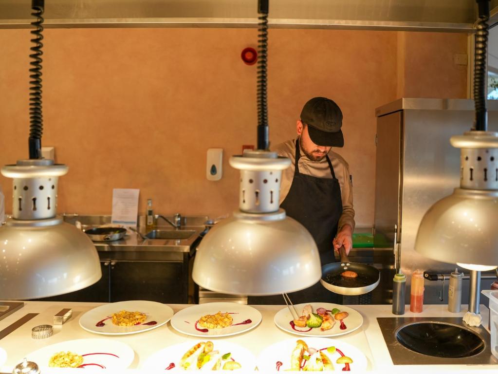 a man in a kitchen preparing food in a kitchen at Thalassa Boutique Hotel & Spa in Coral Bay