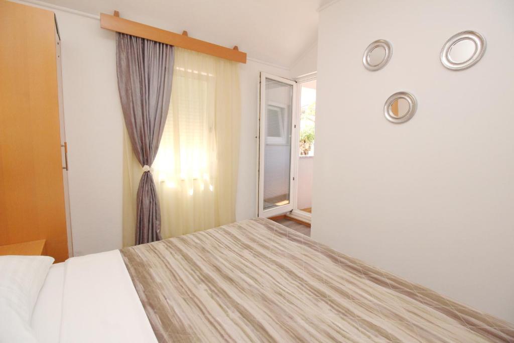 a bedroom with a bed and a window at Villas Corinthia in Baška