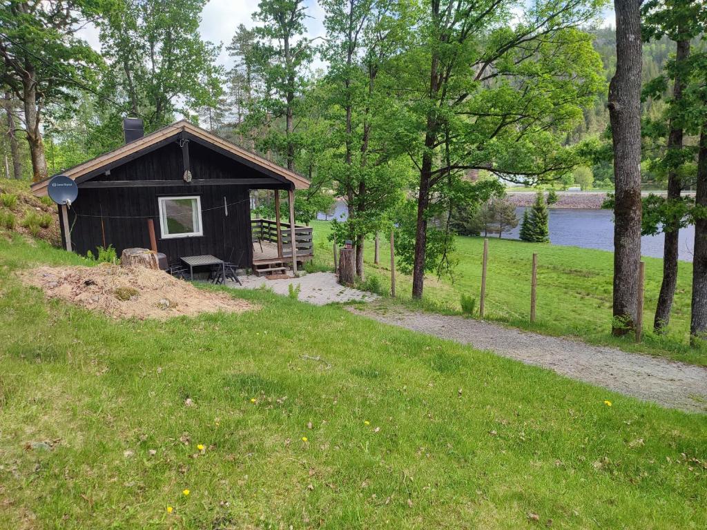 eine kleine Hütte im Gras neben einem Pfad in der Unterkunft Strandheim Two-Bedroom Cottage in Birkeland