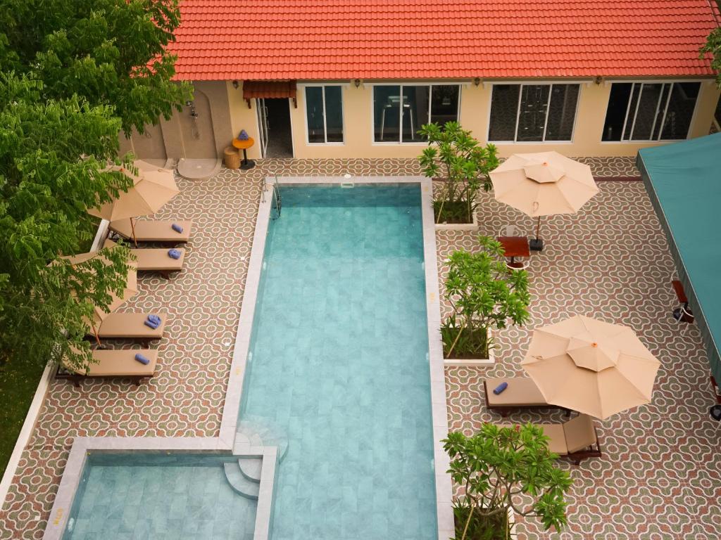Le Kree Downtown Hotel في بنوم بنه: اطلالة علوية على مسبح مع كراسي ومظلات