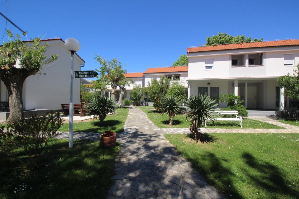 a courtyard of a building with trees and a street sign at Villas Corinthia in Baška