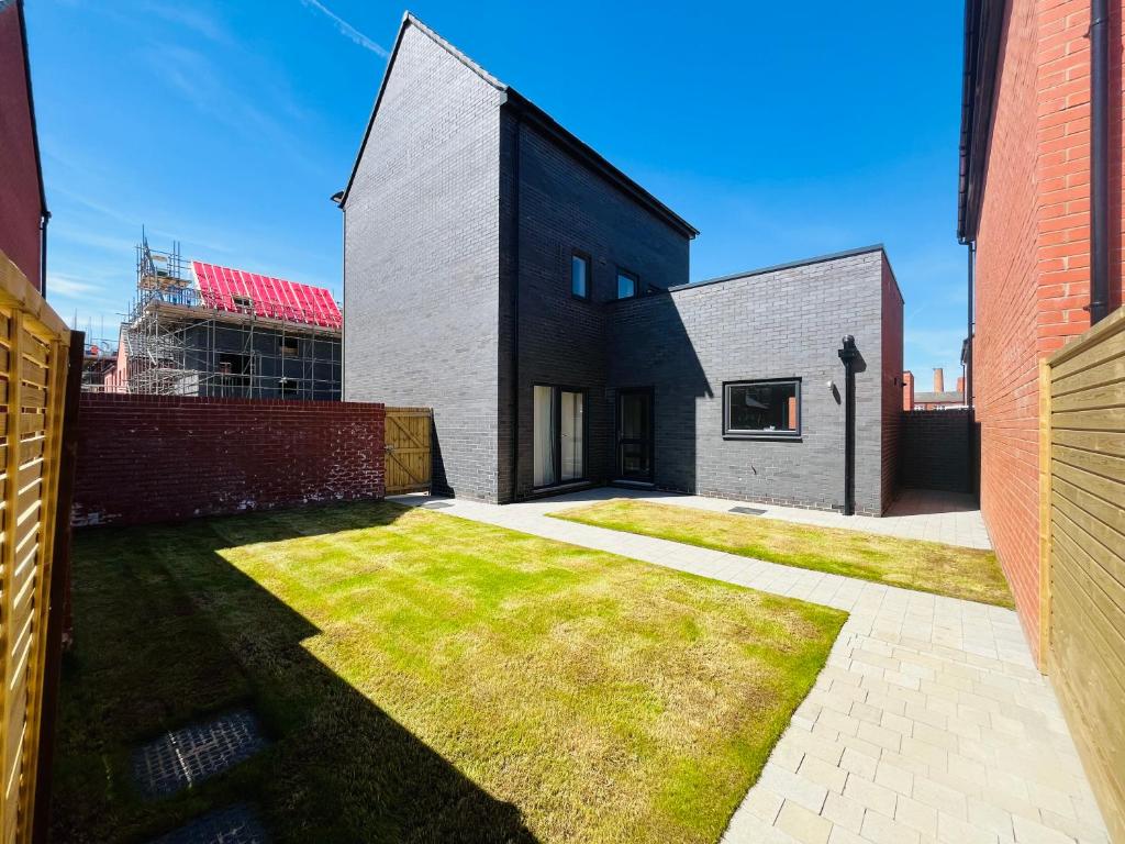 una casa en blanco y negro con un patio de césped en Leicester City 4 Bed home, en Leicester