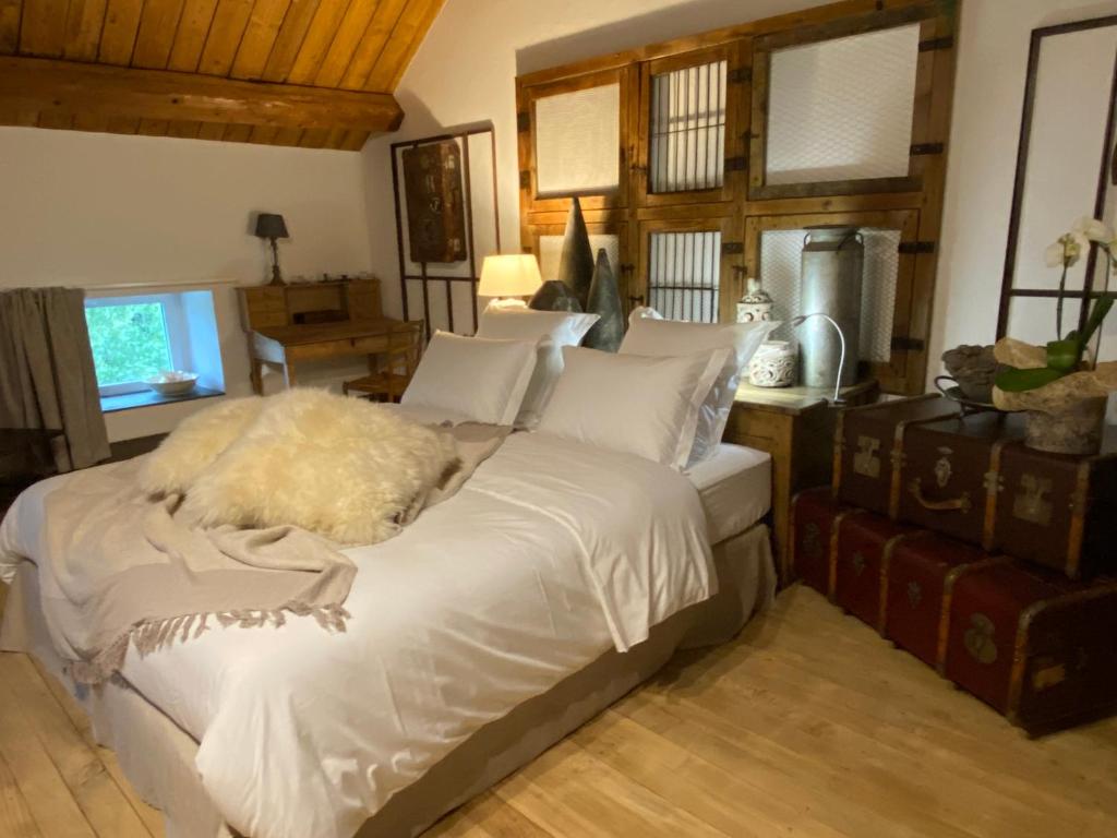 a bedroom with a large bed with white sheets at Le Moulin de Visargent in Sens sur Seille