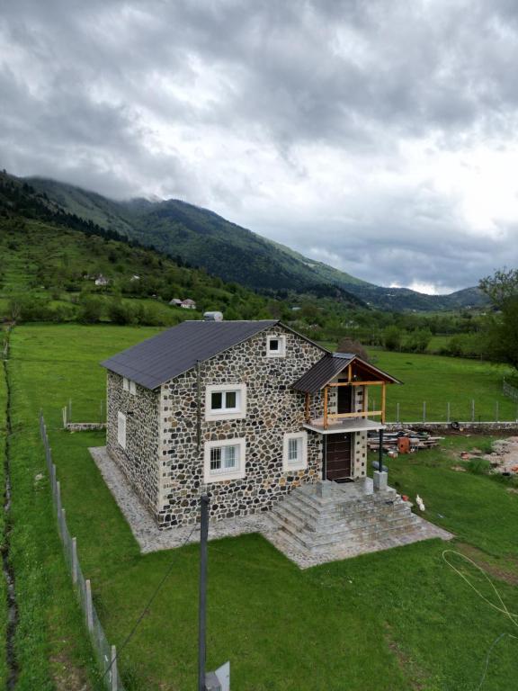 una casa de piedra en medio de un campo en 3 VELLEZERIT DOCI GUEST HOUSE, en Fushë-Lurë