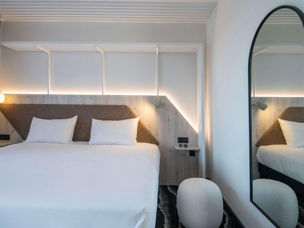 a hotel room with a bed and a mirror at ibis Styles Porto Vecchio in Porto-Vecchio
