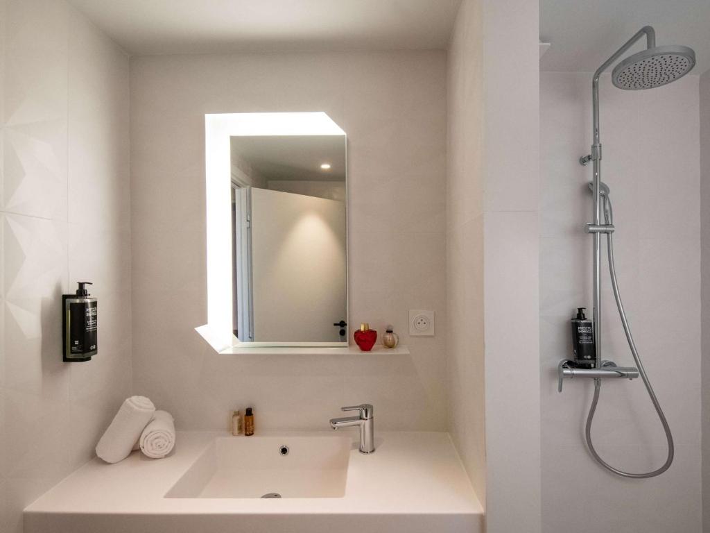 a bathroom with a sink and a shower and a mirror at ibis Styles Porto Vecchio in Porto-Vecchio