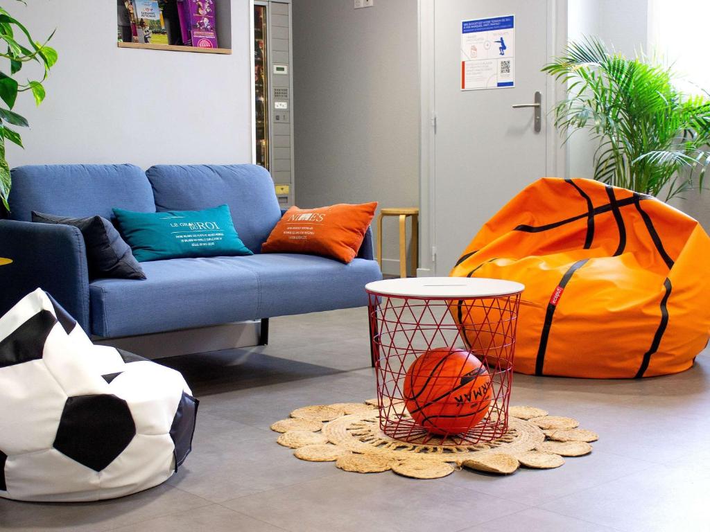 una sala de estar con sofá y una cesta de baloncesto en ibis budget Lunel Porte de Camargue, en Aimargues