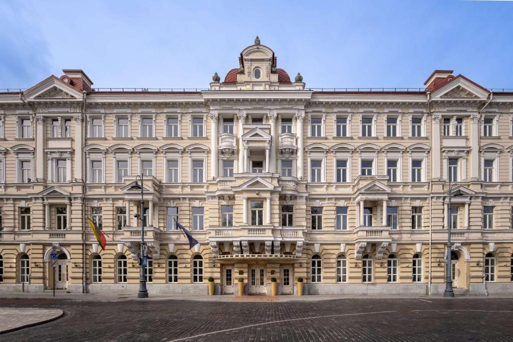 a large neoclassical building in a city at Grand Hotel Vilnius, Curio Collection by Hilton in Vilnius