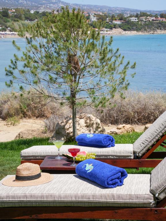 a picnic table with a hat and a drink on it at Thalassa Boutique Hotel & Spa in Coral Bay