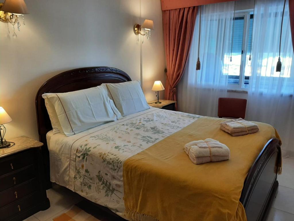 1 dormitorio con 1 cama grande y 2 toallas. en Ocean House, en Costa da Caparica