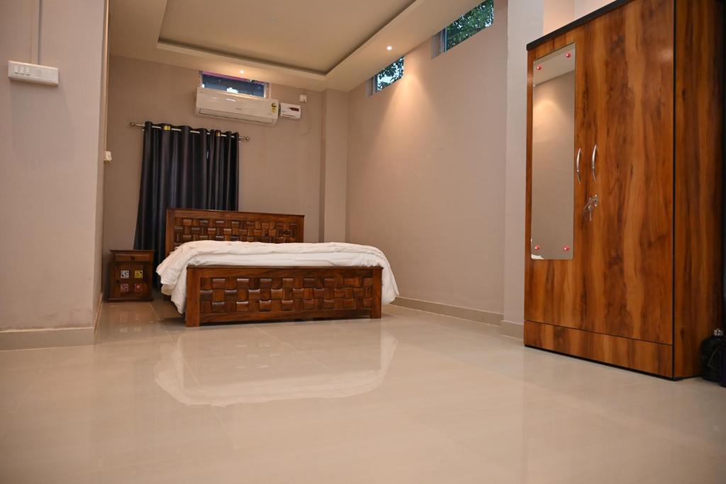 a bedroom with a bed and a wooden door at Palaash Bon in Guwahati
