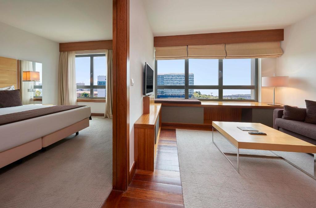 A spacious suite-style interior combining a bedroom with a separate sitting area.