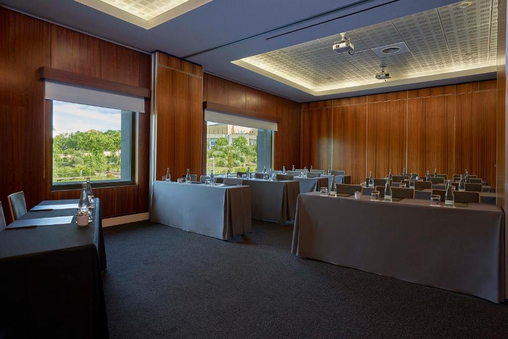 A spacious conference room with multiple table configurations and two large windows.