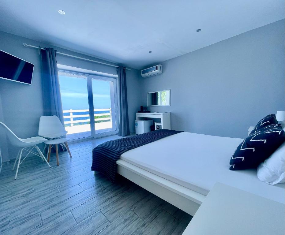 sypialnia z dużym łóżkiem i dużym oknem w obiekcie AGATA BEACH Boutique Adult Only w Achtopolu