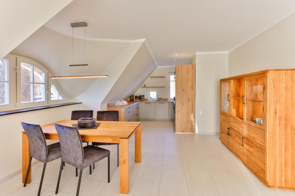 a dining room with a wooden table and chairs at Landhaus Wreechen mit Dachterrasse in Putbus