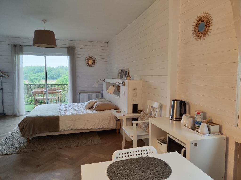 a bedroom with a bed and a table and a desk at La Maison de Boyeux in Châtillon