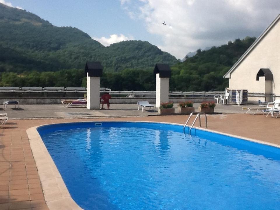 a large blue swimming pool in front of a building at Hotel Escalar in Panticosa