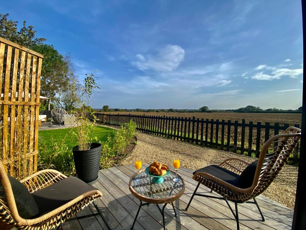 a patio with two chairs and a table with two drinks at Silo Green in Great Dunmow