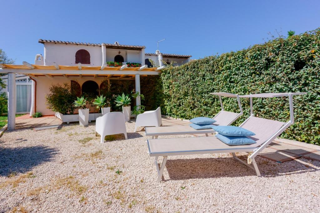 un patio con sillas, un columpio y una casa en Villamarina42, en Flumini di Quartu