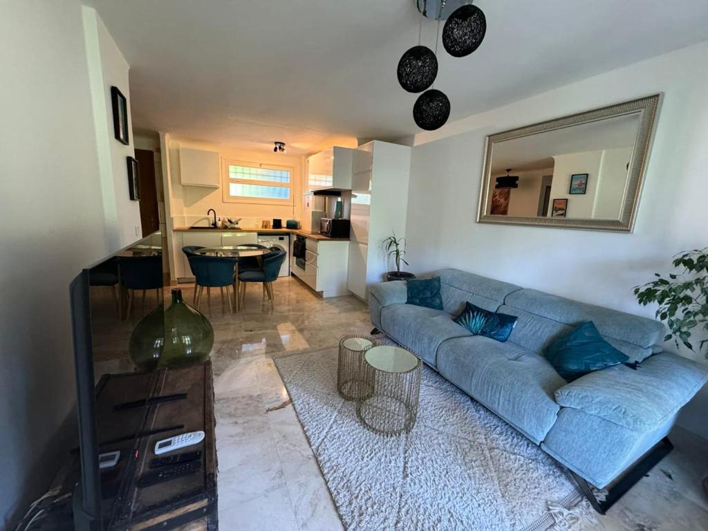 un salon avec un canapé bleu et une cuisine dans l'établissement B023 Tres bel appartement proche de la mer a Cannes, à Cannes