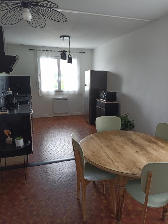 cocina y comedor con mesa y sillas en Appartement Auzances en Auzances