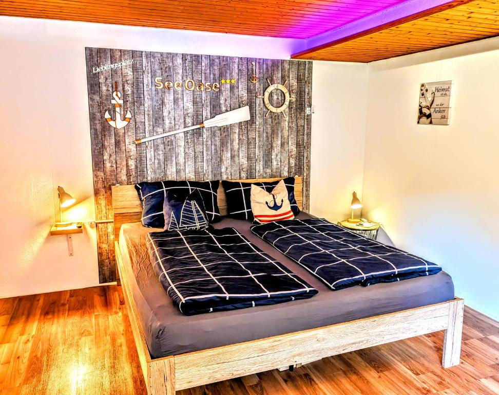 - une chambre avec un lit et une tête de lit en bois dans l'établissement SeeOase Muhr am See inkl Frühstück, à Muhr amSee