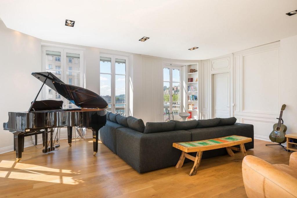 - un salon avec un canapé et un piano dans l'établissement Le Trompettiste - Newly refurbished flat, à Lyon