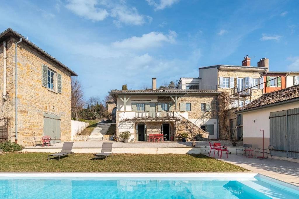 une maison avec une piscine devant une maison dans l'établissement Les Voutes - Beautiful property with swimming pool, à Saint-Didier-au-Mont-dʼOr