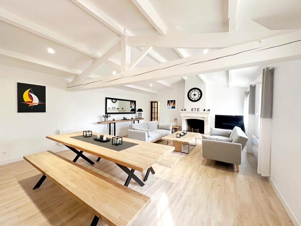 un salon avec une table et un canapé dans l'établissement Superbe longère 4 étoiles à 2 pas de la mer, à Château-dʼOlonne