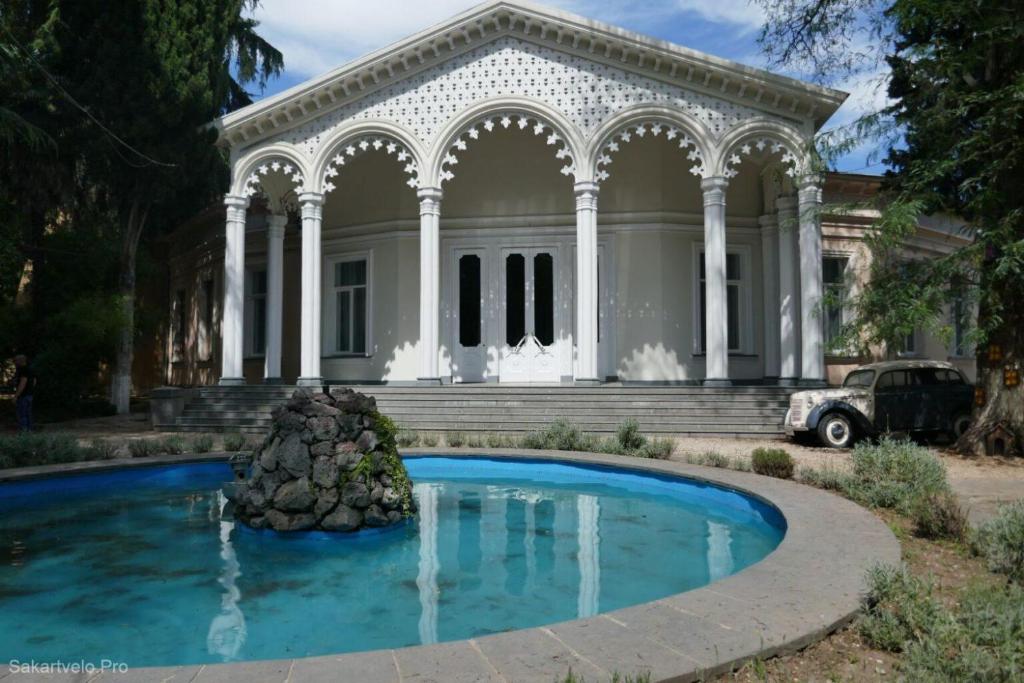 ein Haus mit einem Brunnen davor in der Unterkunft medea in Tbilisi City