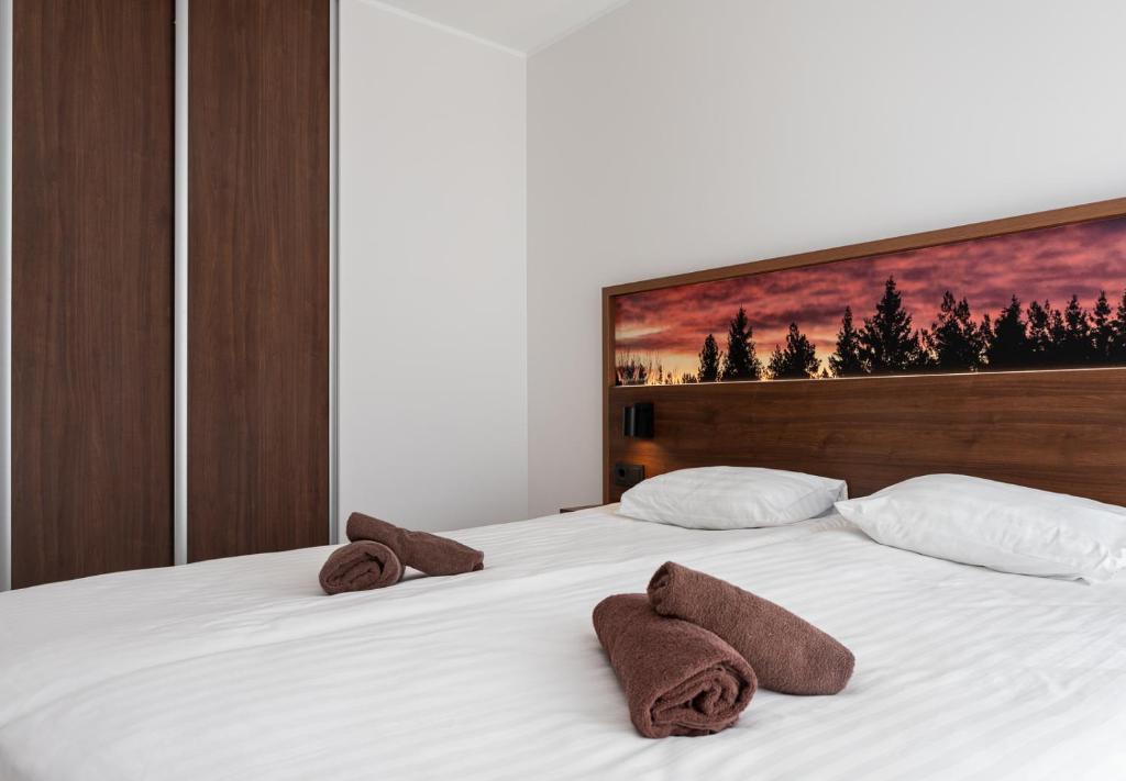 Ö Seaside Suites & SPA في كوريساري: غرفة نوم عليها سرير وفوط