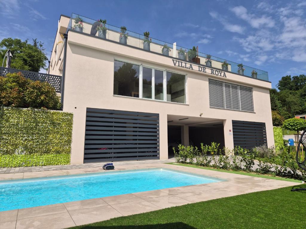 a villa with a swimming pool in front of a house at Villa de Roya in Rogaška Slatina