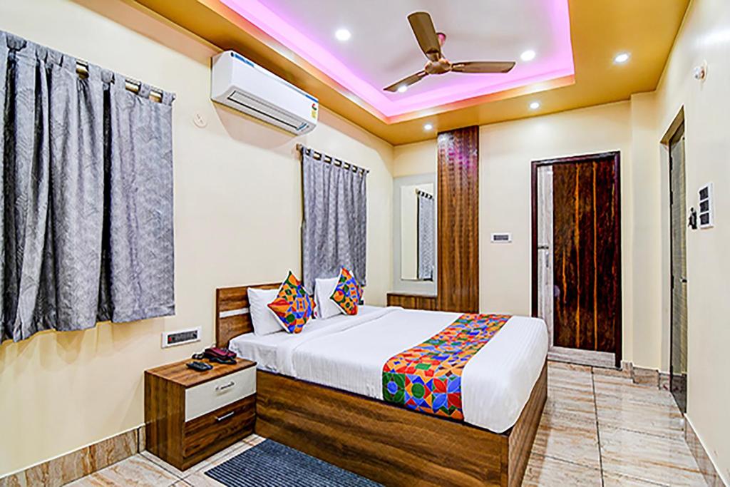 a bedroom with a bed and a ceiling fan at FabHotel Kanan Inn in kolkata