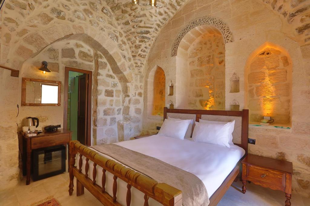 1 dormitorio con 1 cama en una habitación de piedra en Marvel Hotel, en Mardin