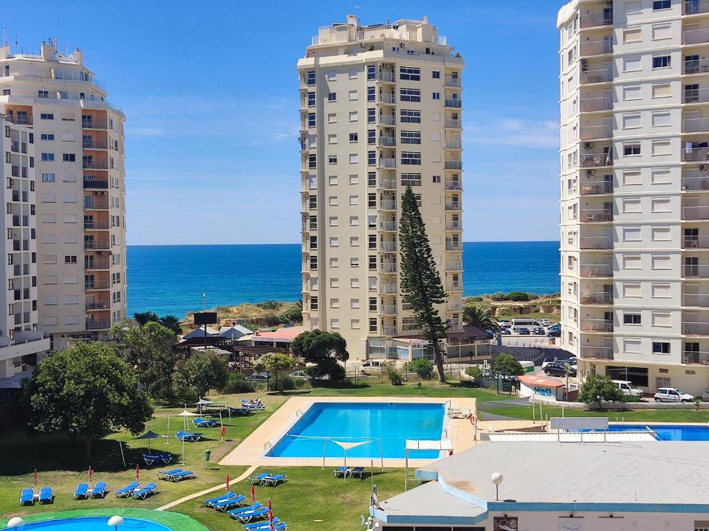 an apartment complex with a swimming pool and two tall buildings at 4D Torre Rafael - Casas & Papéis in Armação de Pêra